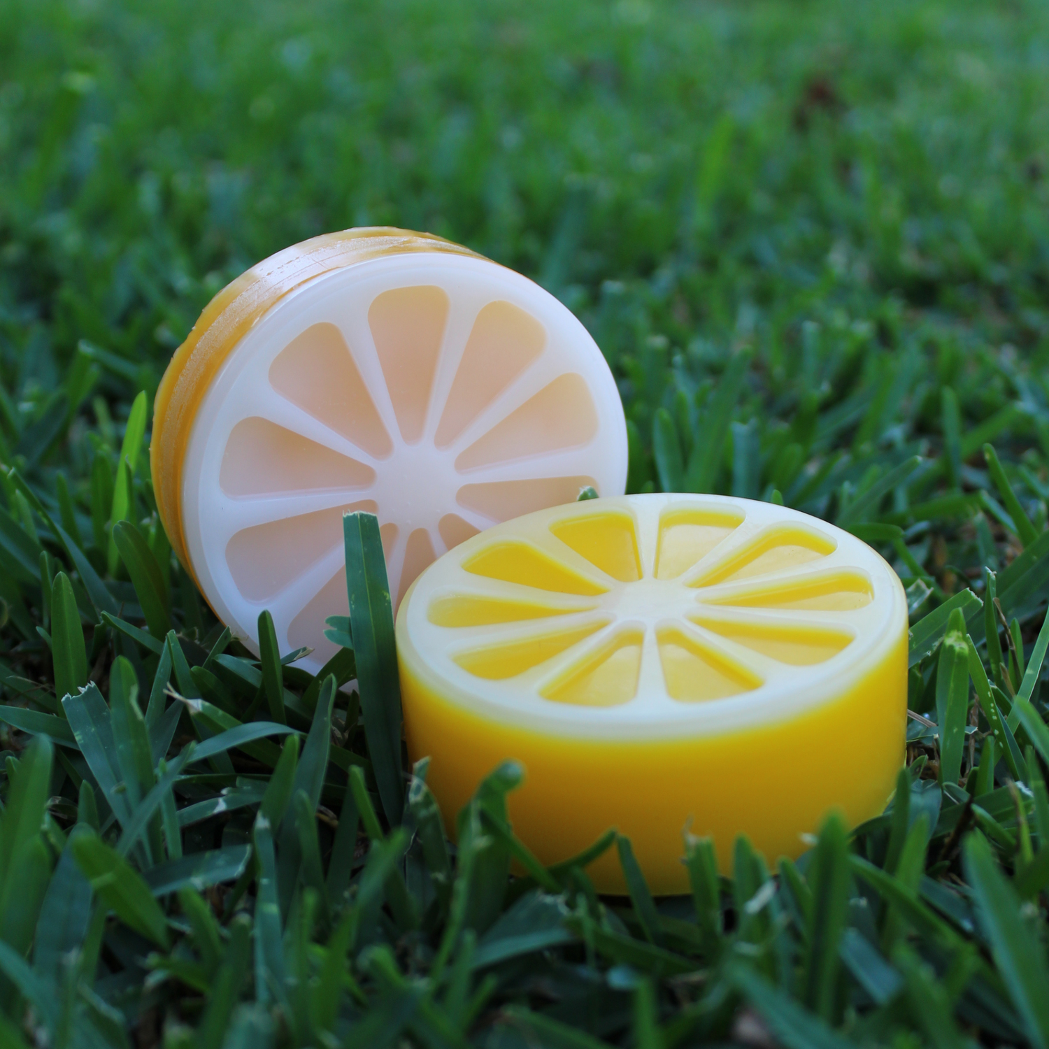 Image displays 2 citrus shaped/colored/scented skate wax rounds